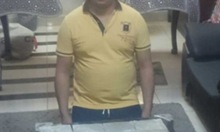 المتهم وأمامه المضبوطات