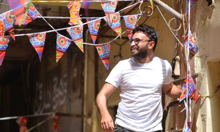أحمد يونس يعلق الزينة بأحد الشوارع
