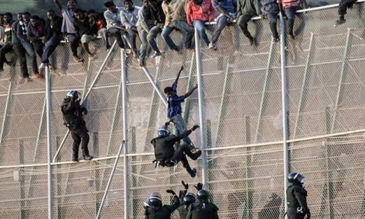 مهاجرون يتسلقون السياج الحديدى فى مليلة