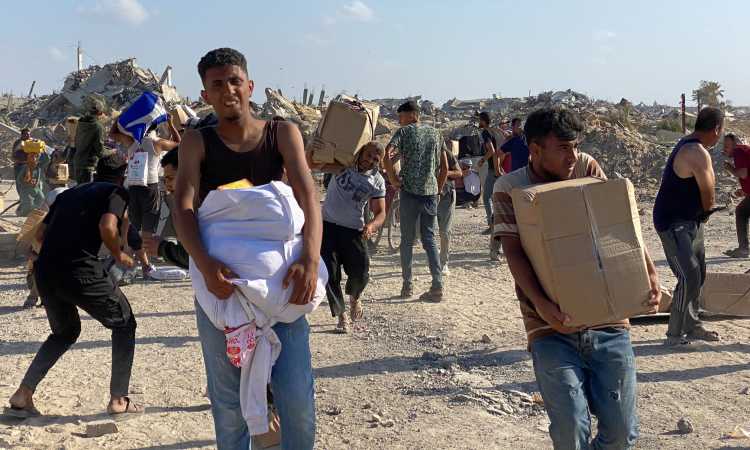 فلسطينيون يتلقون المساعدات وسط إطلاق النار من قبل الاحتلال